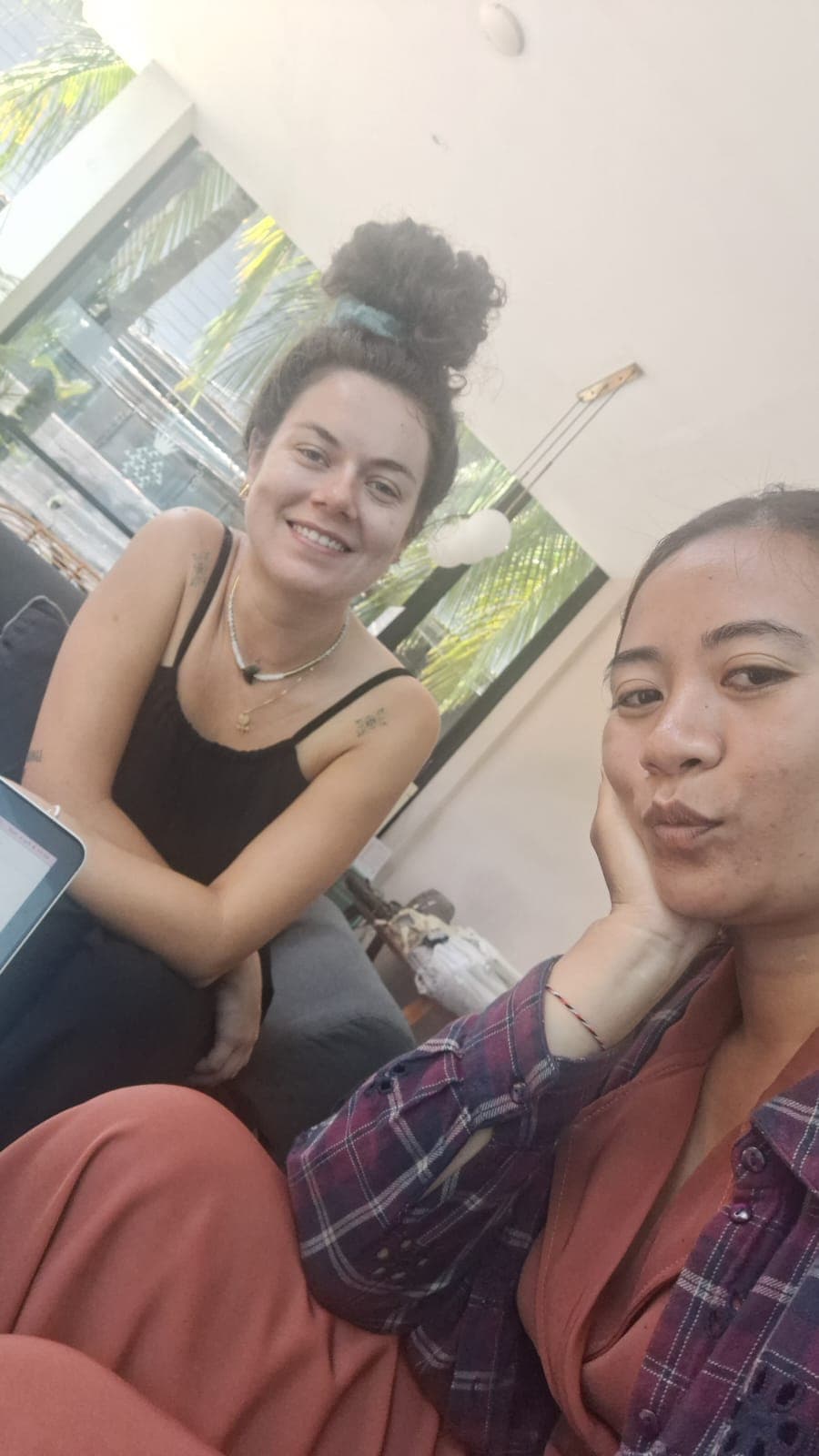 Deux femmes, l'une souriante et l'autre faisant la moue, posent pour un selfie lumineux.